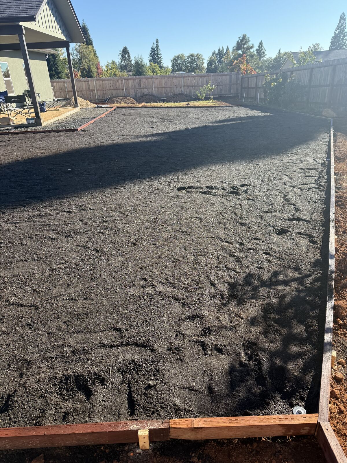 Backyard graded and prepped with fresh soil before sod installation