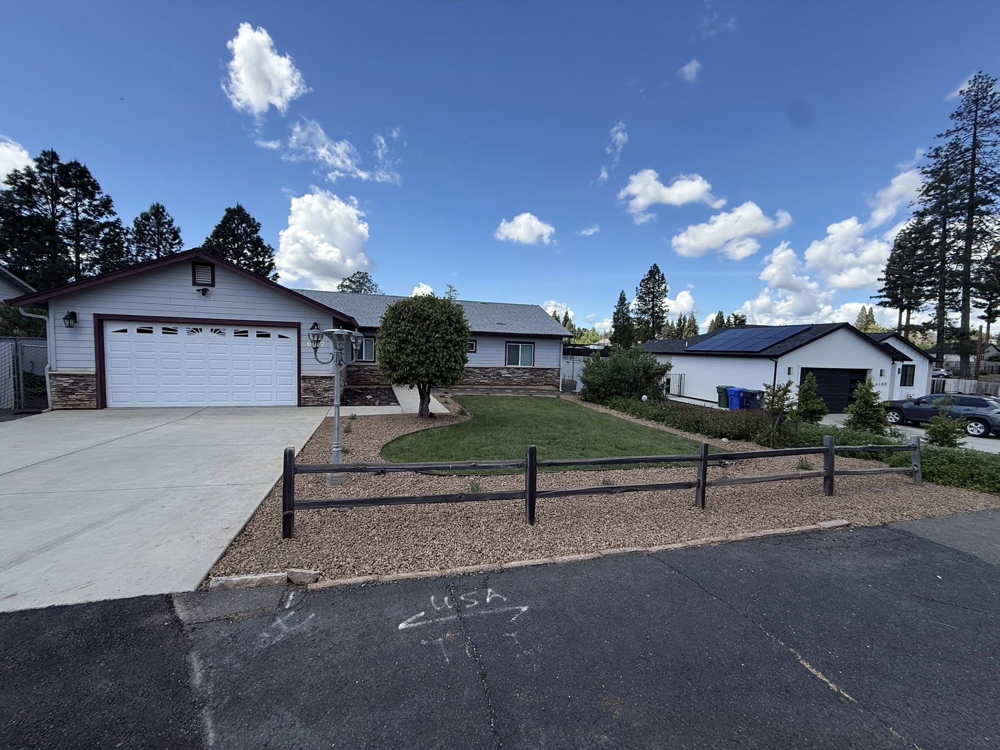 Finished front yard with driveway, rock beds, and lawn