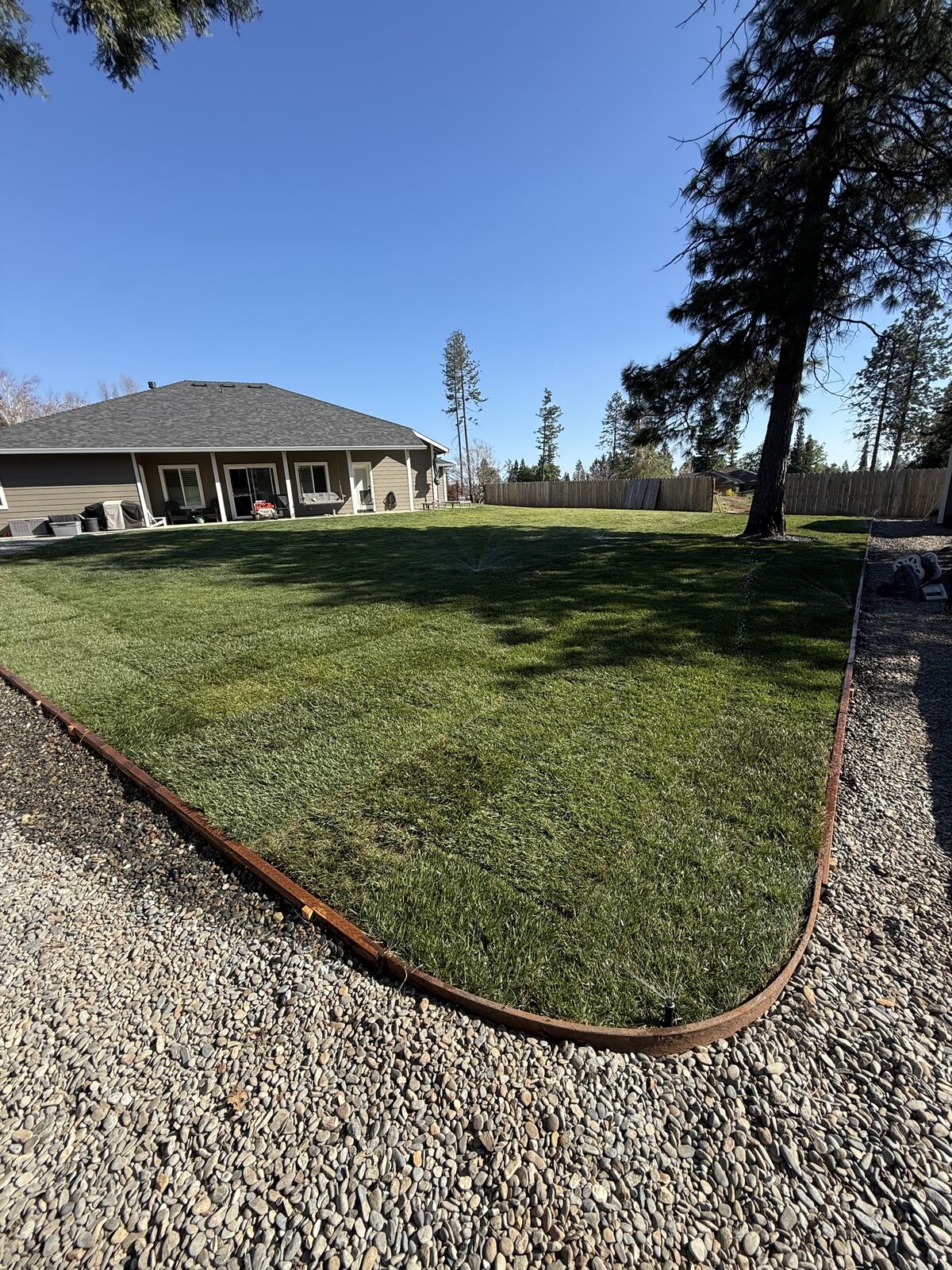Finished lawn with curved river-rock border and clean edges